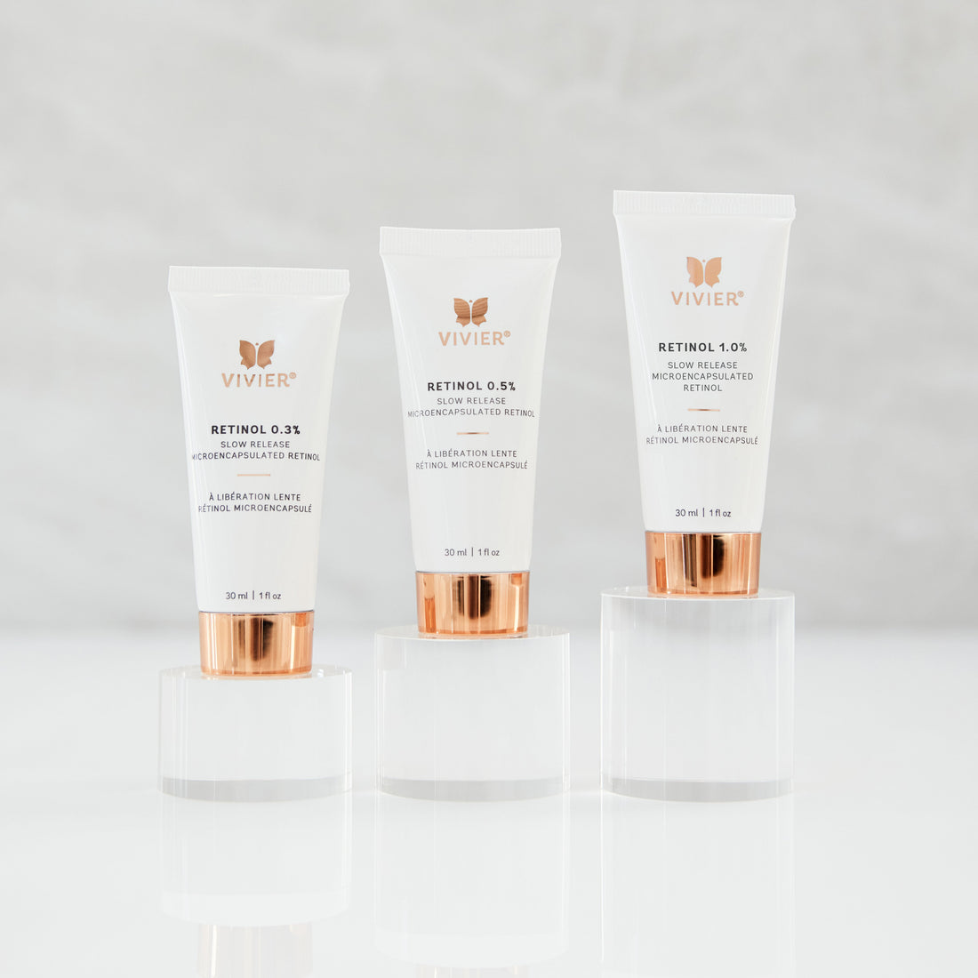 Three Vivier Retinol products (Retinol 0.3%, 0.5%, and 1.0%) standing on clear acrylic platforms against a soft neutral background.