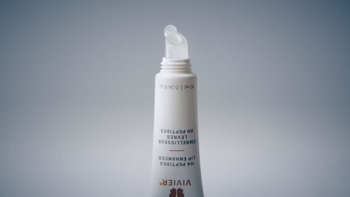 Close-up of a Vivier HA Peptides Lip Enhancer tube with a clear gel formula dispensed from the applicator.